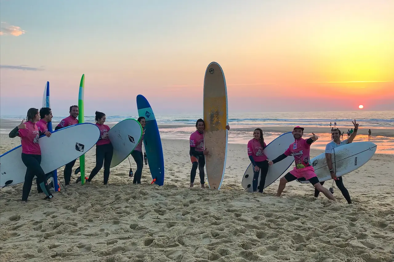 Groupe de stagiaires prenant la pause au coucher du soleil après un cours de surf à Lacanau